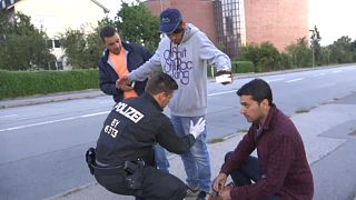 A migrant is searched by police