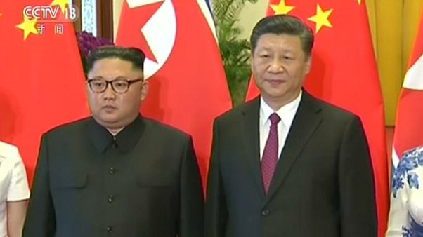 North Korea's Kim Jong-un and China's Xi Jinping stand side by side. North Korea's Kim Jong-un and China's Xi Jinping stand side by side.