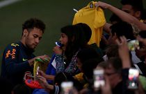 نيمار لاعب منتخب البرازيل يوقع على قميص أحد الجماهير خلال جلسة تدريبية