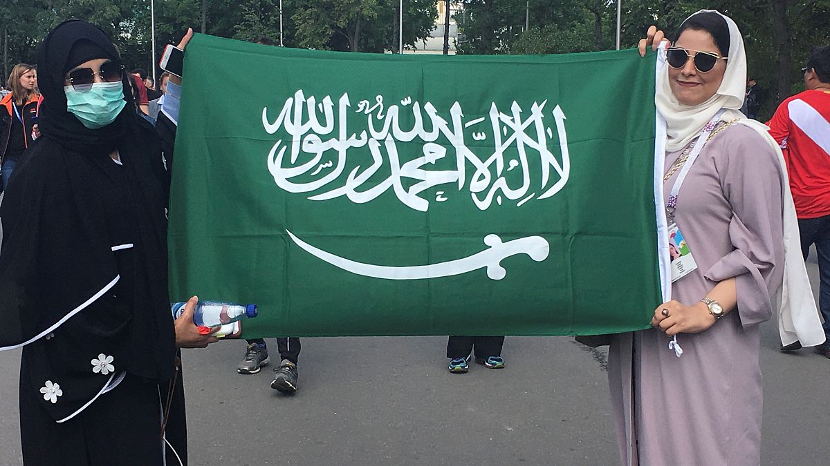 سعوديتان يرفعان علم المملكة خارج استاد لوجنيكي في موسكو