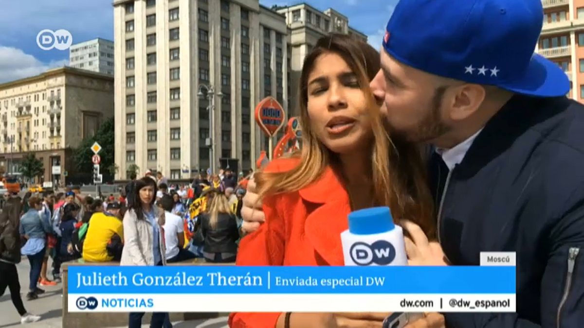 A fan grabs a TV reporter during  a live broadcast 