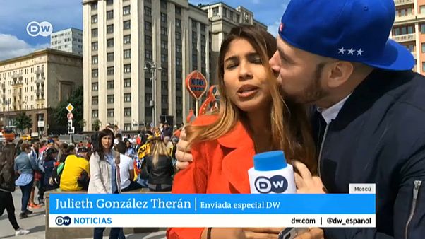 A fan grabs a TV reporter during a live broadcast A fan grabs a TV reporter during a live broadcast