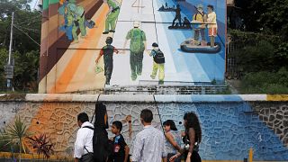 یک خانواده در سان سالوادور پای دیوار روز مهاجرت به آمریکا