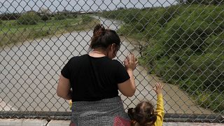 A Honduran mother and daughter seeking asylum wait on the Mexican side of t