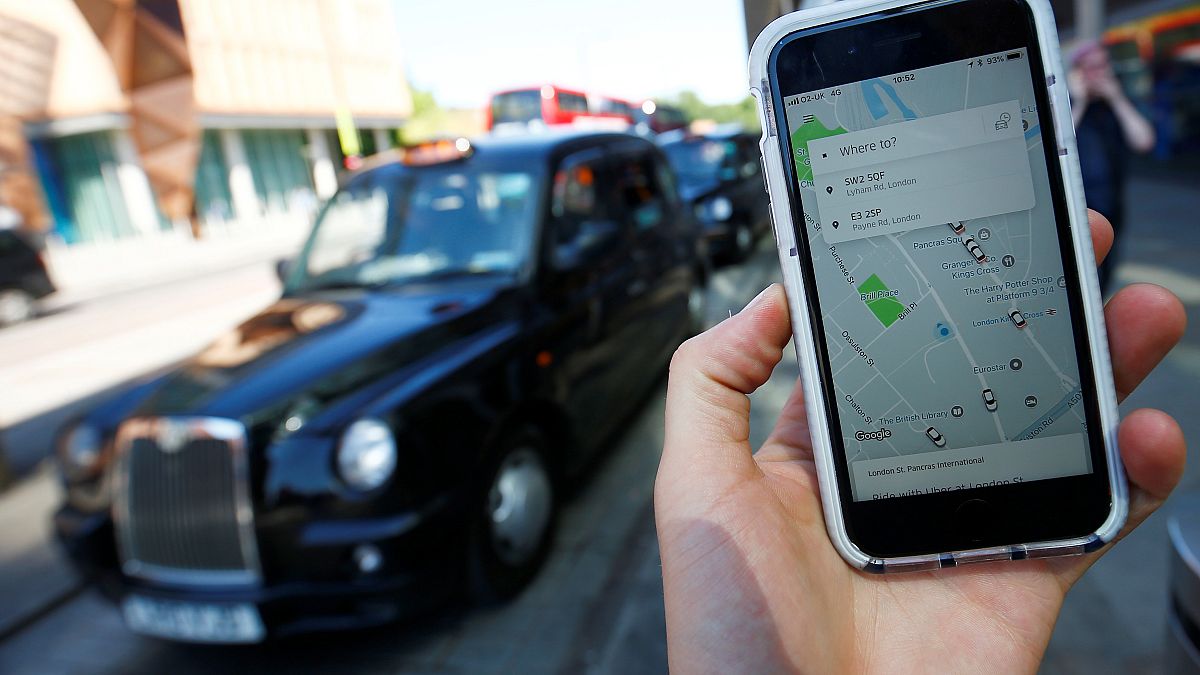 A photo illustration shows Uber app and a black London cab