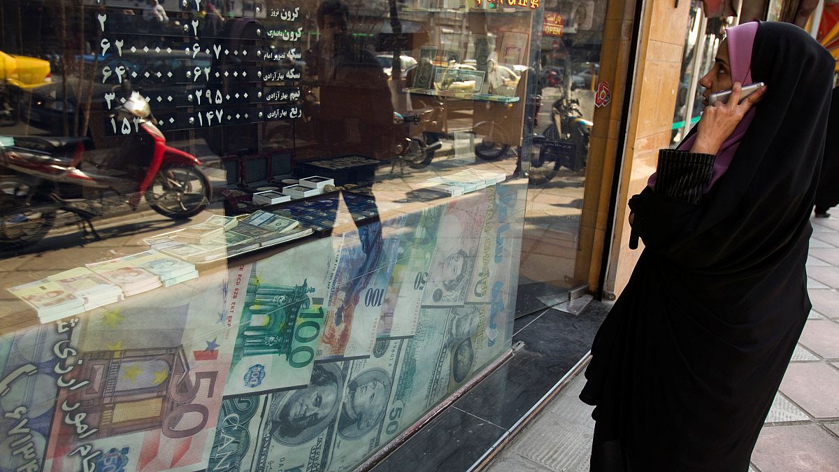 File photo of a woman looking at exchange rates in Tehran