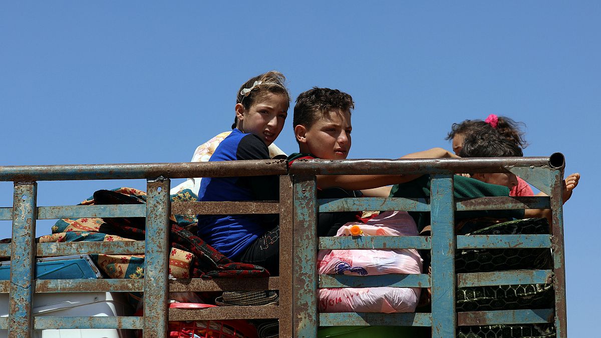 أطفال مع أمتعتهم فارّون من العنف المتصاعد في ريف درعا - علاء الفقير رويترز