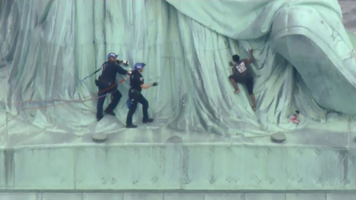 Police seize woman who clambered up Statue of Liberty