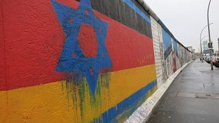 Davidstern auf Deutschlandflagge auf einem Stück Berliner Mauer