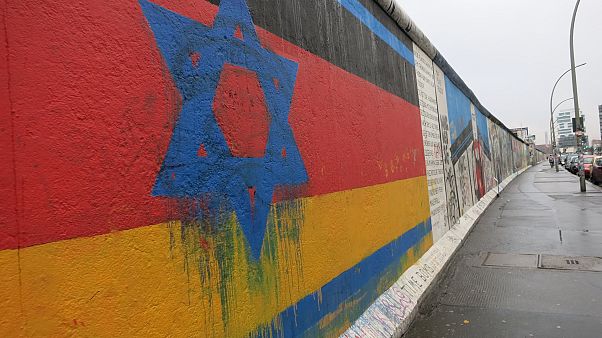 Davidstern auf Deutschlandflagge auf einem Stück Berliner Mauer Davidstern auf Deutschlandflagge auf einem Stück Berliner Mauer