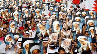 محتجون يحملون صورا لرجل الدين الشيعي البارز آية الله نعيم قاسم