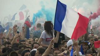Une femme fêtent la victoire des Bleus dans la foule