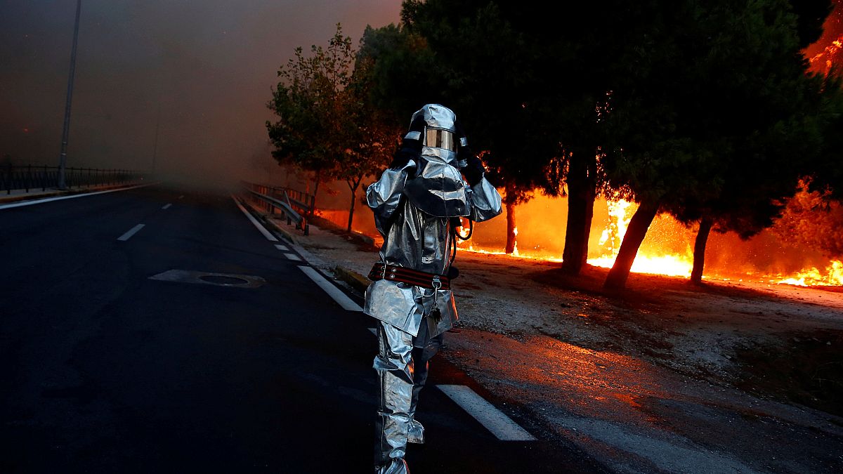 Un pompier en équipement lutte contre les incendies près d'Athènes, Grèce