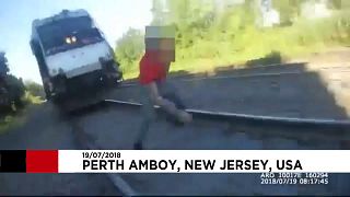 پلیس جوان مردی را بر روی ریل از مرگ حتمی رهاند
