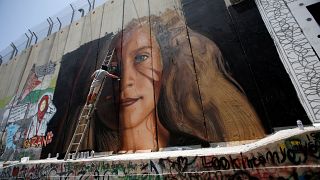 الشارع الفلسطيني يستعد لاستقبال عهد التميمي ورسامون أجانب يشاركون في التحضيرات