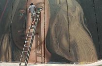( Lo street artist italiano mentre esegue un murale di Tamimi a Betlemme)