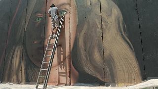 ( Lo street artist italiano mentre esegue un murale di Tamimi a Betlemme)