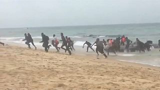 شاهد لحظة وصول مهاجرين أفارقة  إلى شاطئ سياحي في إسبانيا وسط دهشة المصطافين