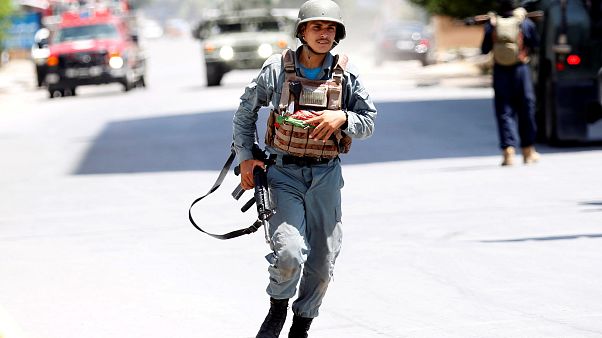 Ein afghanischer Polizist eilt zu einem der Orte, wo Feuer zu sehen ist Ein afghanischer Polizist eilt zu einem der Orte, wo Feuer zu sehen ist