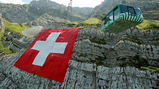 Eine riesige Flagge der Schweiz hängt derzeit am Berg Säntis in den Alpen.