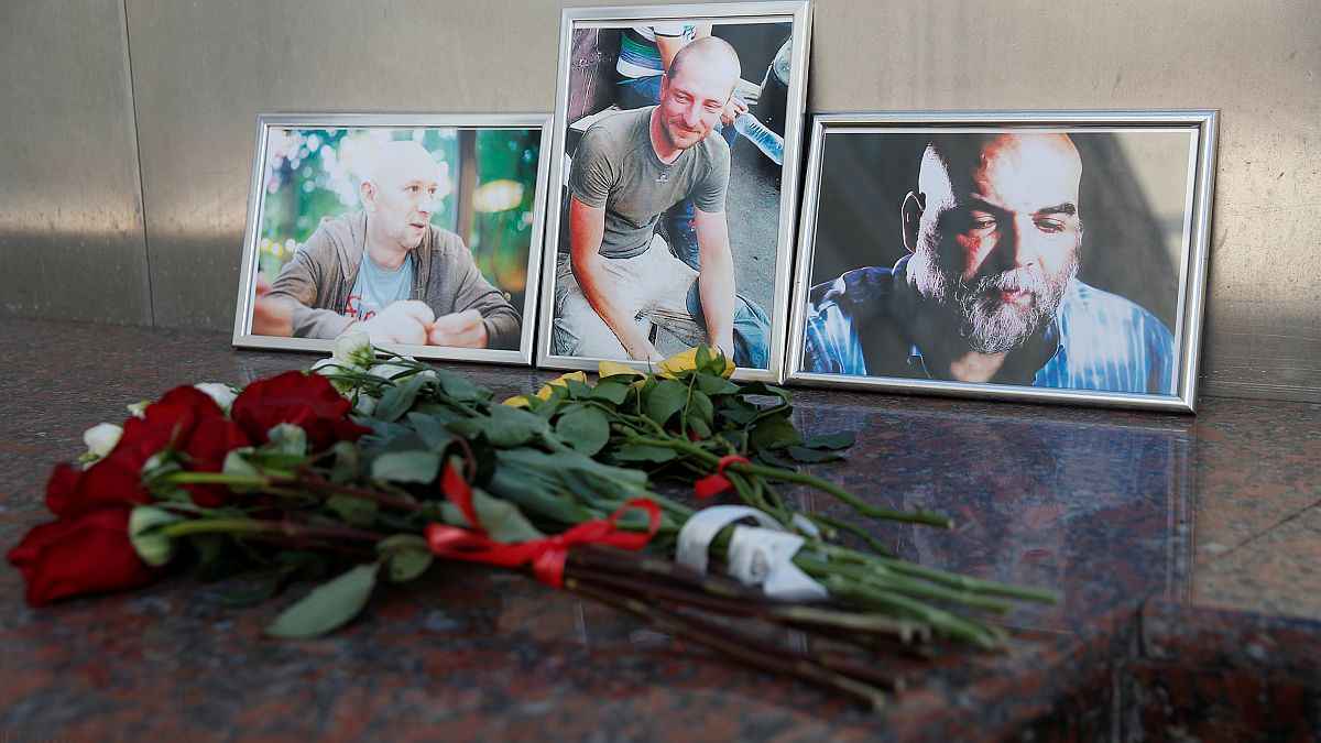 A három meggyilkolt újságíró fényképe előtt virágok Moszkvában