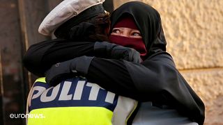 شرطية تعانق مسلمة تتظاهر احتجاجا على منع الحجاب