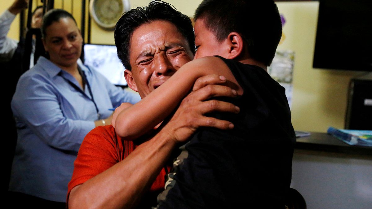 أب من غواتيمالا يعانق ابنه بعد أن تم فصلهمها على الحدود الأمريكية - رويترز.