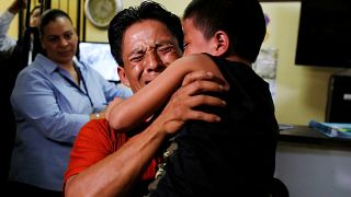 أب من غواتيمالا يعانق ابنه بعد أن تم فصلهمها على الحدود الأمريكية - رويترز.