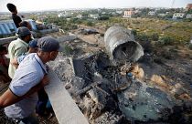 فلسطينيون ينظرون إلى الدمار الذي سببه القصف الإسرائيلي ببلدة المغراقة بغزة