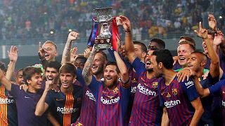 لاعبو فريق برشلونة يرفعون كأس السوبر الإسبانية بعد فوزهم على أشبيلية