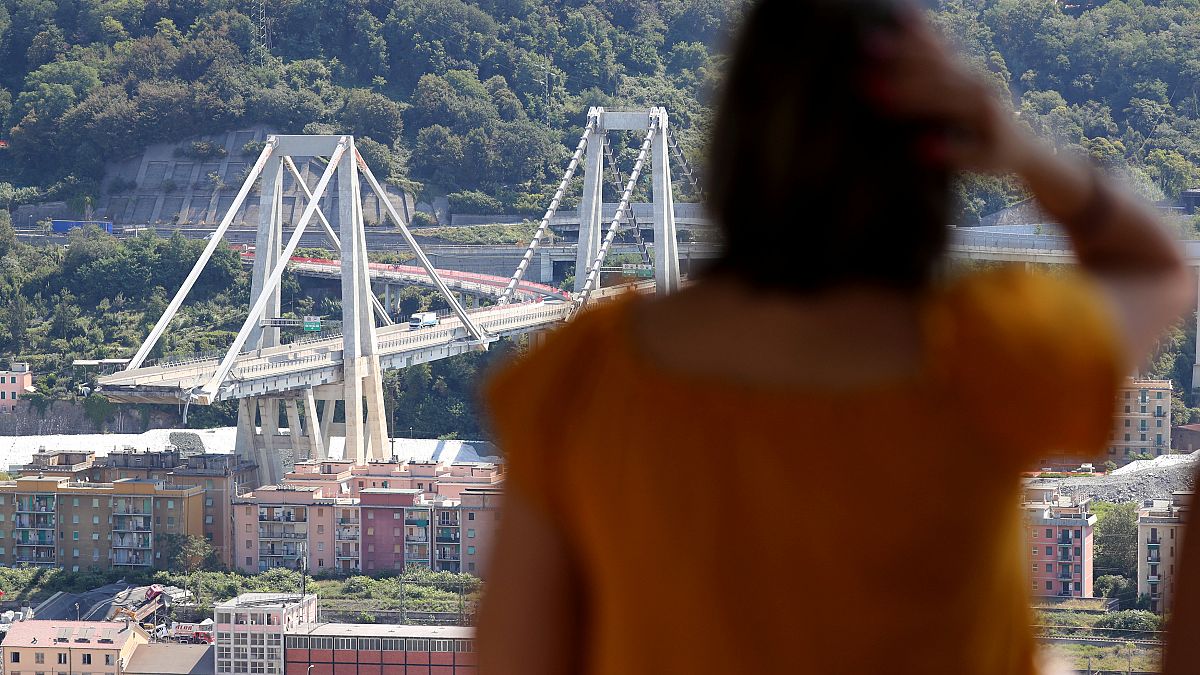 Eine Frau blickt auf die eingestürzte Brücke in Genua