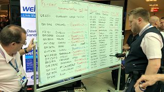 Gatwick staff display flight information on a whiteboard on August 20, 2018