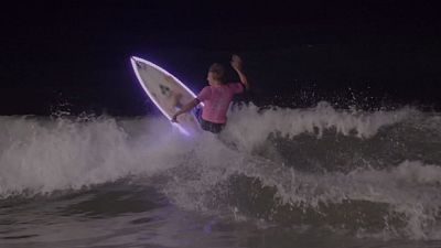 Watch: Surfers catch waves under moonlight