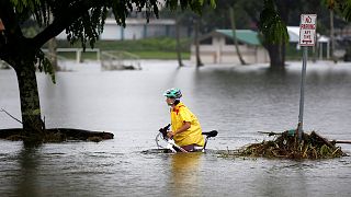 امرأة تدفع دراجتها عبر الفيضانات الناجمة عن إعصار لين في هيلو - رويترز