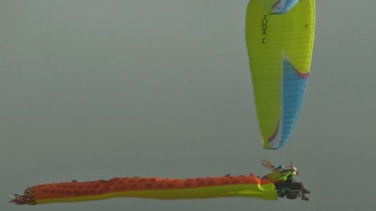 Watch: Costume-clad paragliders descend over the Andes