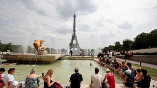Des touristes au bord d'une fontaine non loin de la Tour Eiffel à Paris
