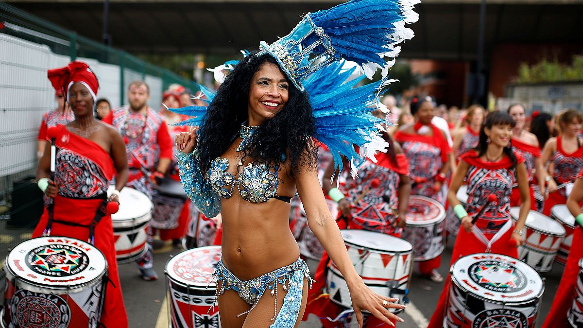 Une danseuse et des musiciens lors du carnaval de Notthing Hill à Londres