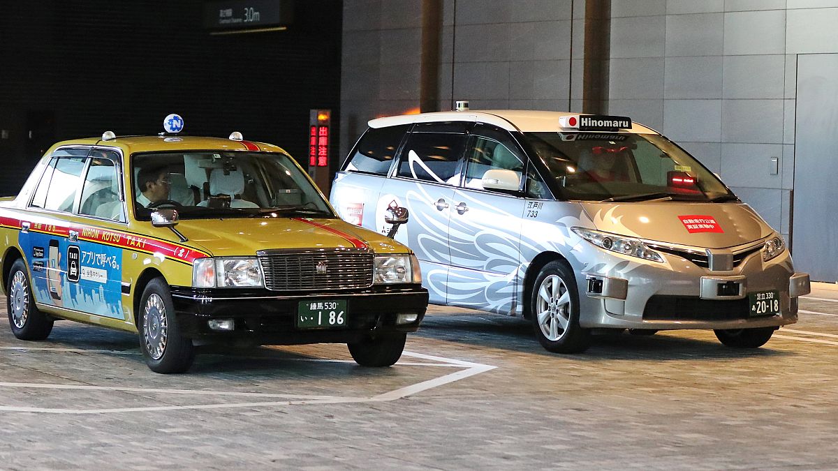 Egy hagyományos és egy önvezető taxi Tokióban