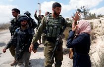 Una mujer palestina frente a un soldao israelí en la aldea de Ras Karkar