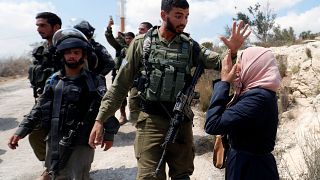 Una mujer palestina frente a un soldao israelí en la aldea de Ras Karkar