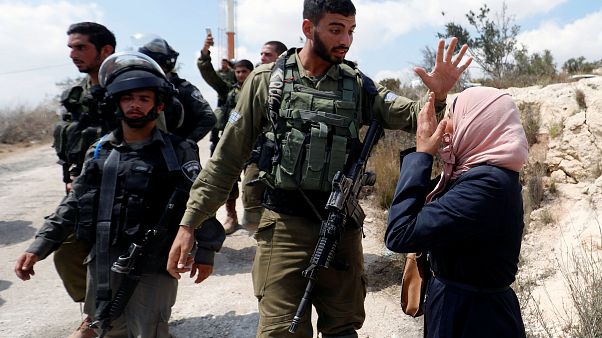 Una mujer palestina frente a un soldao israelí en la aldea de Ras Karkar Una mujer palestina frente a un soldao israelí en la aldea de Ras Karkar
