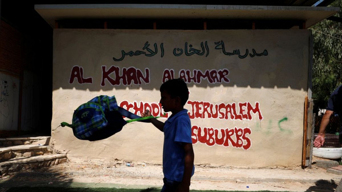 یک کودک فلسطینی در کنار مدرسه خان‌الاحمر