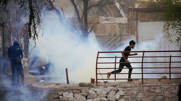 متظاهر عراقي يهرب من غاز مسيل للدموع اثناء الاحتجاجات متظاهر عراقي يهرب من غاز مسيل للدموع اثناء الاحتجاجات