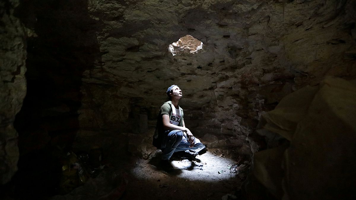 A man takes shelter in an underground cave in Idlib, Syria