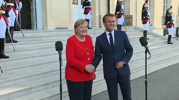 Macron e Merkel destacam as migrações no debate europeu Macron e Merkel destacam as migrações no debate europeu