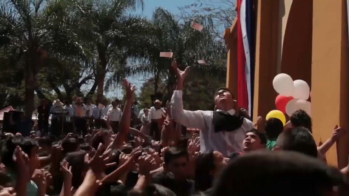 Cientos de niños a la caza de billetes en una fiesta religiosa en Paraguay
