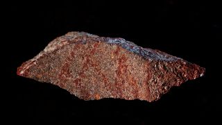 Marcature rosso ocra su una piccola pietra scoperta nella grotta di Blombos