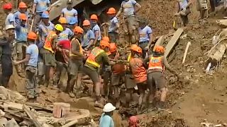 rescue workers dig for bodies after a landslide in northern Philippines