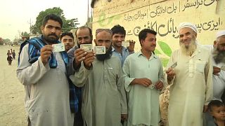 مواطنون أفغان يحملون بطاقات هوية كلاجئين في أحد معسكرات اللاجئين في باكستان