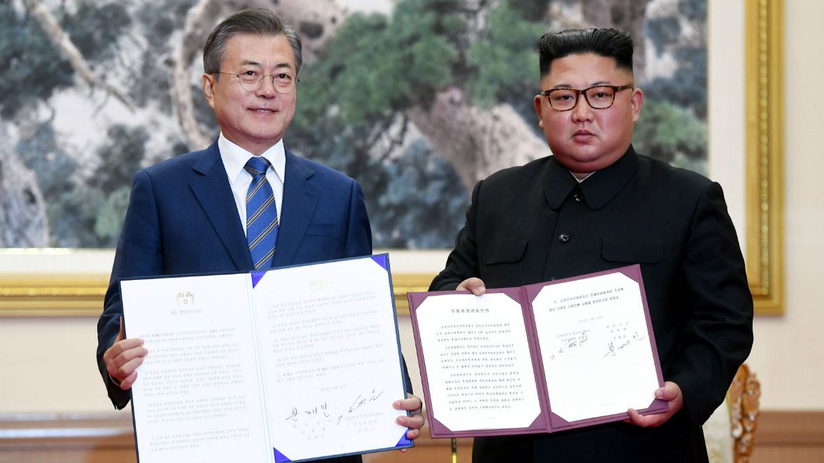 Moon Jae-in shakes hands with North Korean leader Kim Jong Un 